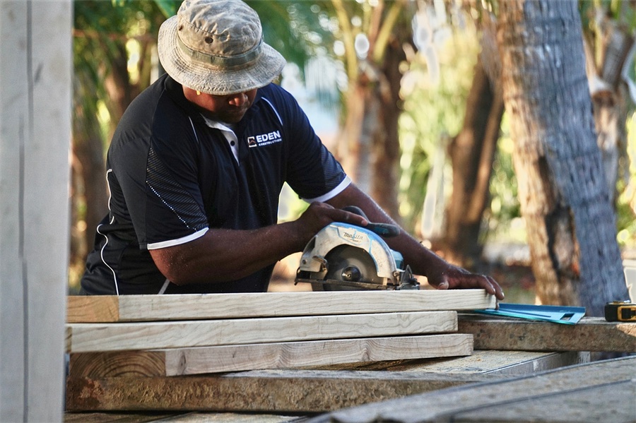 Carpenter cutting timber with a circular saw