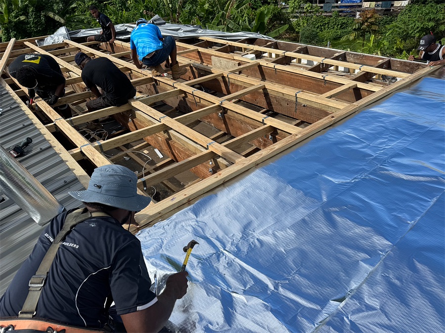 Eden crew member in uniform fixing the new roof
