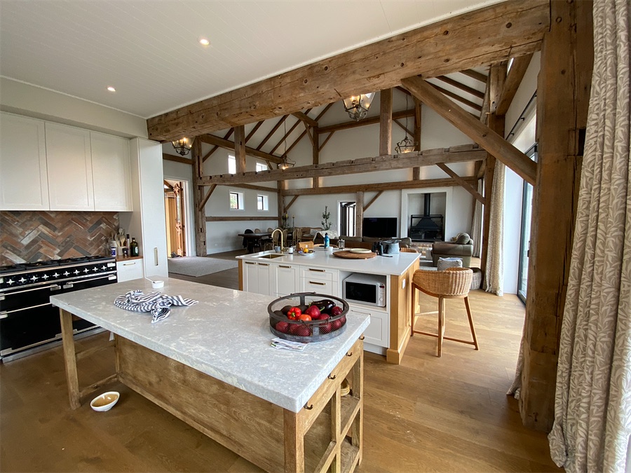 Kitchen beneath reclaimed timber trusses