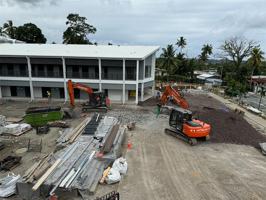Commercial building under construction with excavators on site